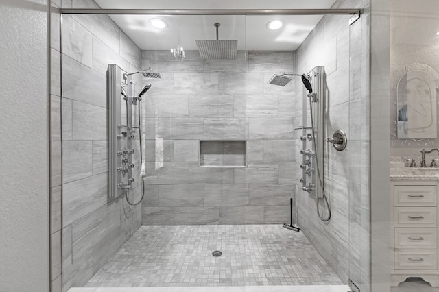 bathroom featuring walk in shower and vanity