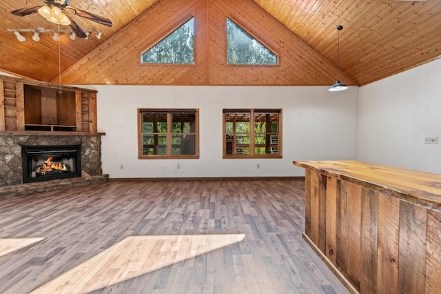 unfurnished living room with wood ceiling, ceiling fan, wood-type flooring, a stone fireplace, and high vaulted ceiling