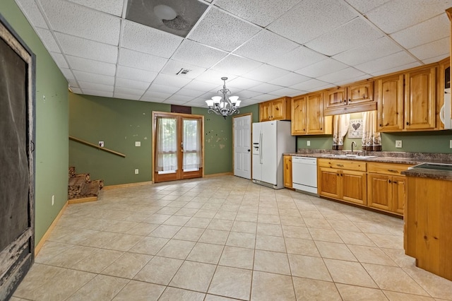 kitchen featuring an inviting chandelier, white appliances, sink, a paneled ceiling, and pendant lighting