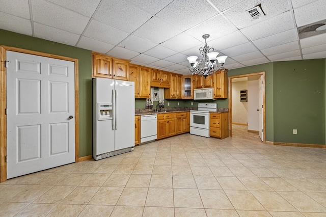 kitchen featuring pendant lighting, white appliances, light tile patterned floors, an inviting chandelier, and sink