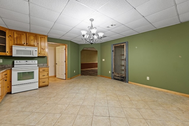 kitchen featuring hanging light fixtures, an inviting chandelier, white appliances, and a drop ceiling