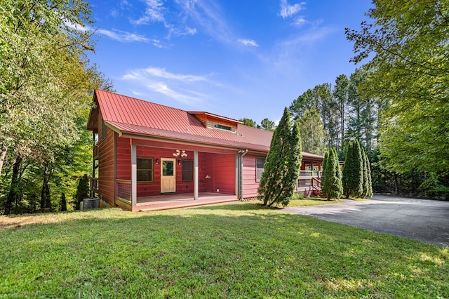 view of front of home with a front lawn, covered porch, and central AC