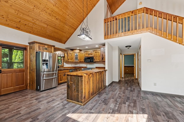 kitchen featuring stainless steel appliances, wood-type flooring, kitchen peninsula, high vaulted ceiling, and pendant lighting