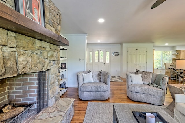 living room with baseboards, a fireplace, recessed lighting, and wood finished floors