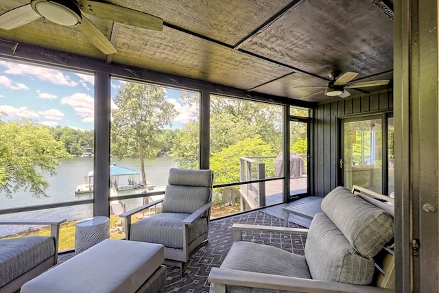 sunroom / solarium with a water view and ceiling fan