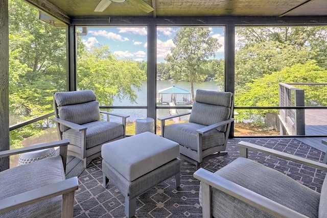 sunroom / solarium with a water view, ceiling fan, and a healthy amount of sunlight