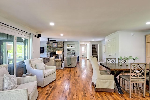 living room with crown molding, a ceiling fan, a wealth of natural light, and hardwood / wood-style flooring