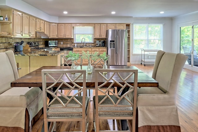 kitchen featuring tasteful backsplash, open shelves, light brown cabinets, stainless steel appliances, and light wood-style flooring