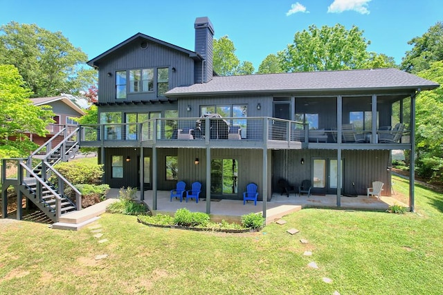 back of property featuring a deck, stairway, a chimney, a patio, and a yard