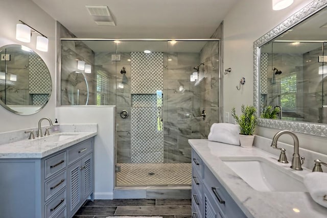 full bath with visible vents, a shower stall, and a sink