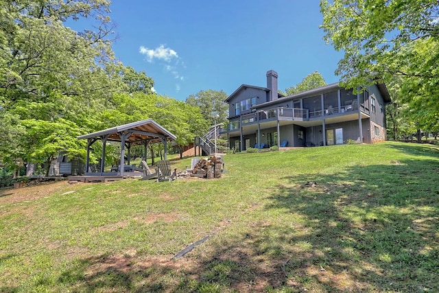 view of yard featuring stairway, a gazebo, a wooden deck, and a sunroom