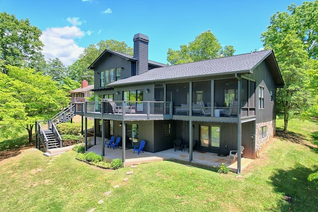 back of property with a lawn, a chimney, stairs, and a patio area