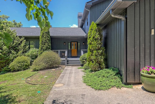 view of front of property featuring board and batten siding, a chimney, and a porch