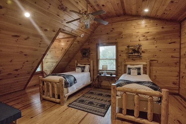 bedroom with wooden walls, vaulted ceiling, hardwood / wood-style floors, wood ceiling, and ceiling fan