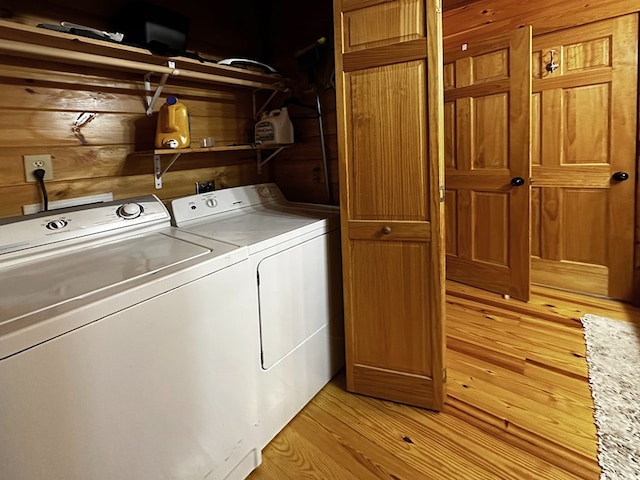 laundry area featuring separate washer and dryer and light hardwood / wood-style flooring