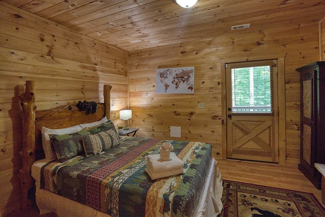 bedroom featuring hardwood / wood-style flooring, wood ceiling, and wooden walls