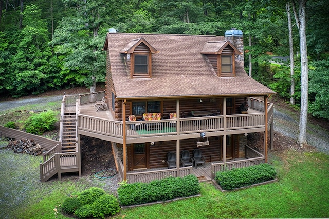 rear view of property featuring a deck and a lawn