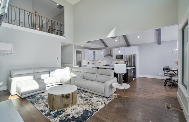 living room featuring visible vents, baseboards, beamed ceiling, dark wood-style floors, and high vaulted ceiling