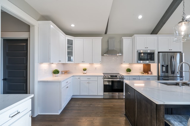 kitchen with dark wood-style floors, a sink, decorative backsplash, stainless steel appliances, and wall chimney range hood