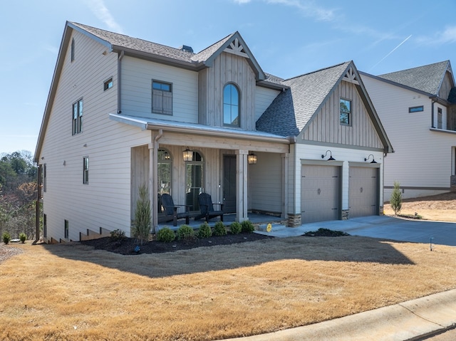 view of front of house with a garage, a front lawn, and covered porch