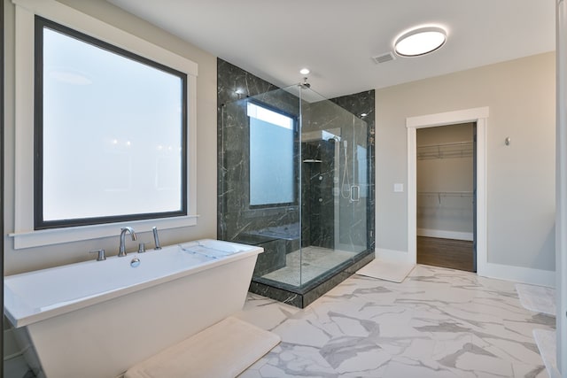 full bath with a marble finish shower, a spacious closet, baseboards, a freestanding bath, and marble finish floor