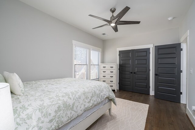 bedroom featuring a closet, a ceiling fan, visible vents, and dark wood-style flooring