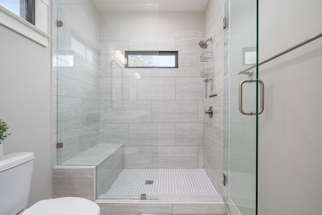 bathroom with a shower stall and toilet