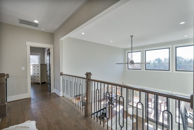 hallway featuring a wealth of natural light, visible vents, and wood finished floors