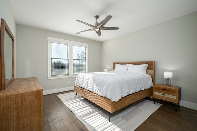 bedroom featuring ceiling fan, baseboards, and dark wood-style floors