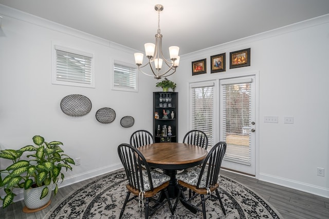 dining space with a chandelier, dark wood-type flooring, and ornamental molding