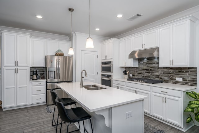 kitchen featuring sink, decorative light fixtures, a kitchen island with sink, white cabinets, and appliances with stainless steel finishes