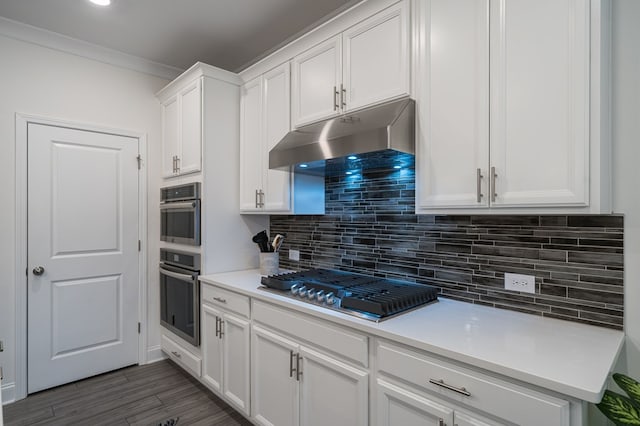 kitchen with dark wood-type flooring, decorative backsplash, double oven, white cabinetry, and gas cooktop