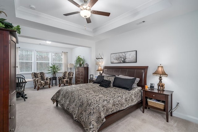 carpeted bedroom with a raised ceiling, ceiling fan, and crown molding