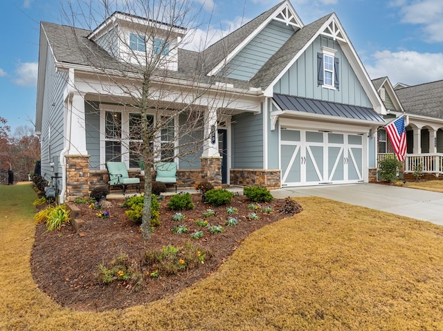 craftsman-style home with a front lawn, covered porch, and a garage