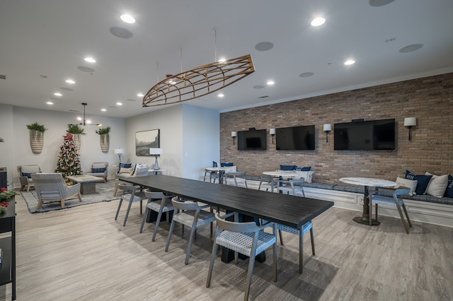 dining area featuring light hardwood / wood-style floors and brick wall