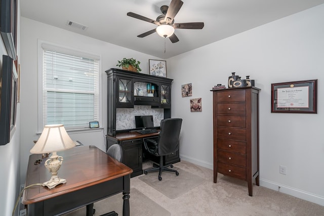 carpeted office space featuring ceiling fan