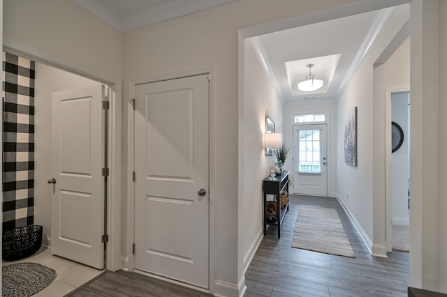 foyer entrance with crown molding and hardwood / wood-style floors