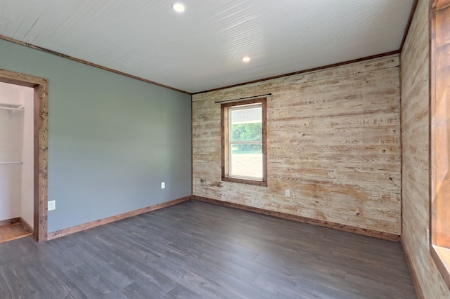 spare room featuring hardwood / wood-style flooring and wooden walls