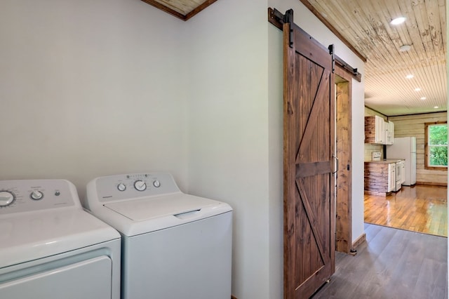 laundry area with washing machine and dryer, a barn door, wooden ceiling, wood-type flooring, and ornamental molding