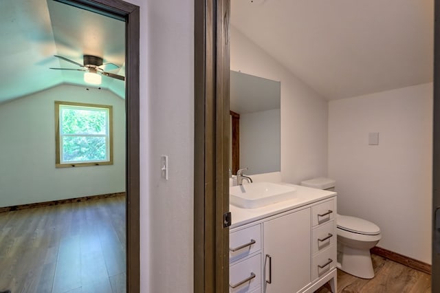 bathroom featuring lofted ceiling, toilet, vanity, ceiling fan, and hardwood / wood-style flooring