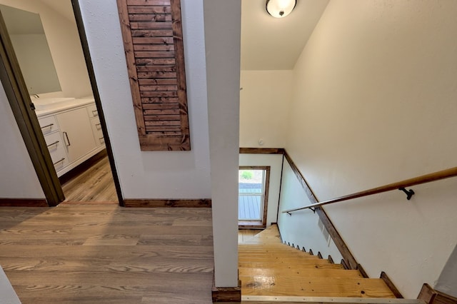 stairs featuring light hardwood / wood-style flooring and sink