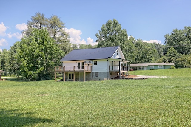 rear view of property featuring a wooden deck and a lawn