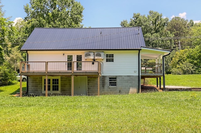 back of house featuring a lawn and a wooden deck