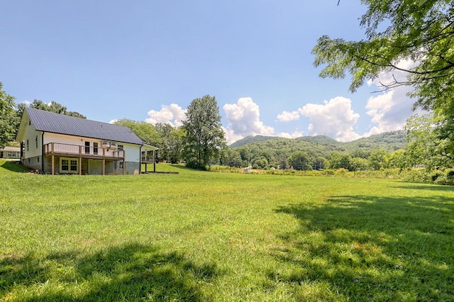 view of yard with a deck with mountain view