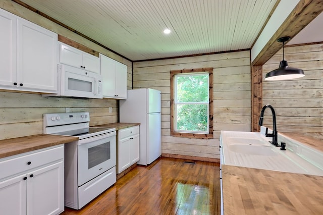 kitchen with decorative light fixtures, wooden counters, wooden walls, hardwood / wood-style floors, and white appliances