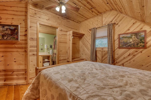 bedroom featuring lofted ceiling, wood ceiling, hardwood / wood-style flooring, wooden walls, and ceiling fan