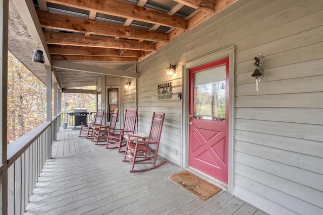 wooden terrace with area for grilling and a porch