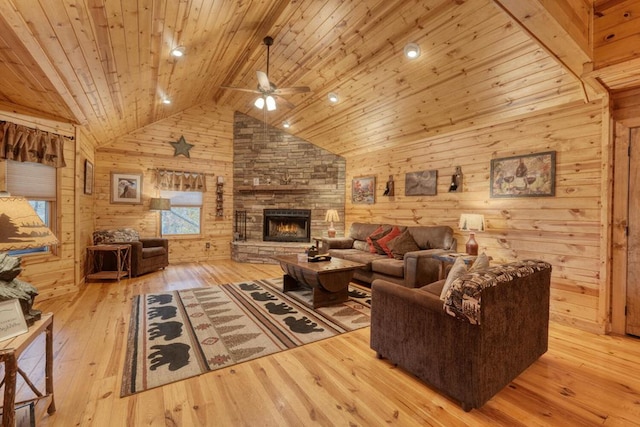 living room with ceiling fan, high vaulted ceiling, wooden ceiling, wood walls, and light hardwood / wood-style floors