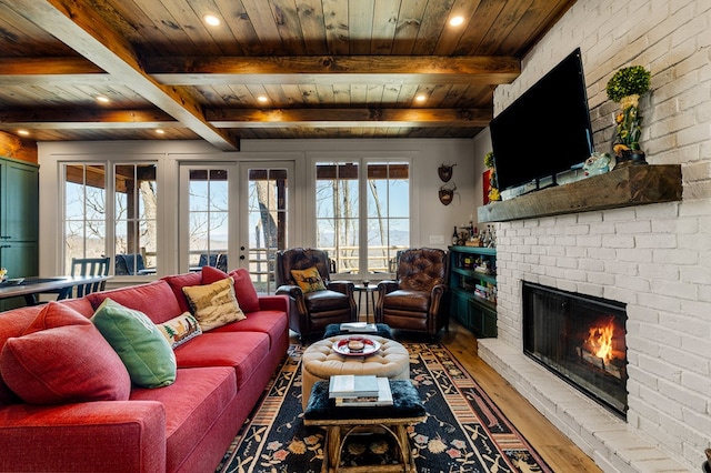 living room featuring wooden ceiling, a brick fireplace, a healthy amount of sunlight, and wood finished floors