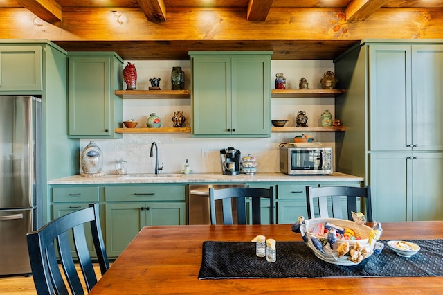 kitchen with appliances with stainless steel finishes and green cabinets